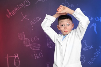 Photo of Emotional pupil against blackboard with written chemistry formulas. Space for text