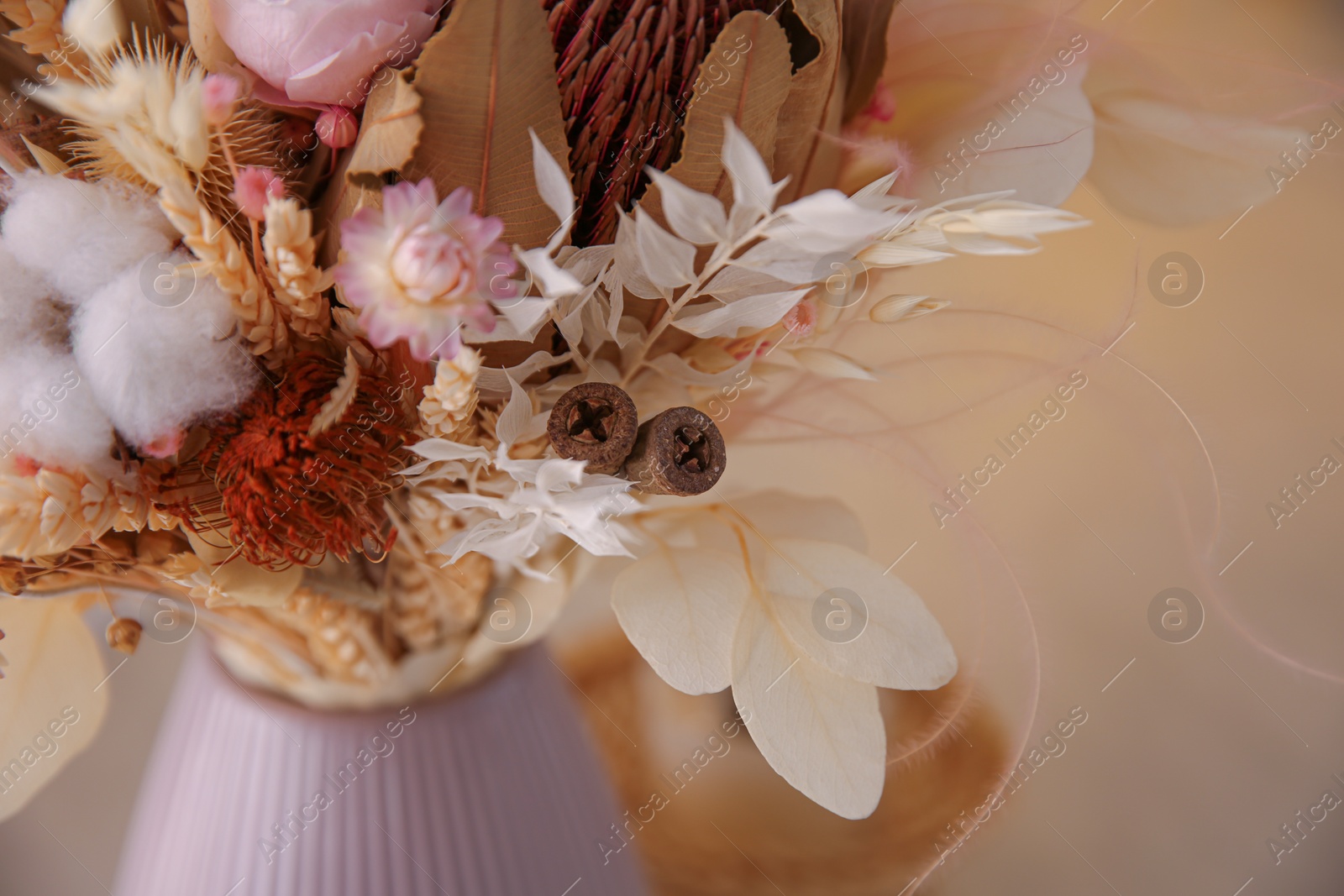 Photo of Bouquet of dry flowers and leaves on blurred background, closeup