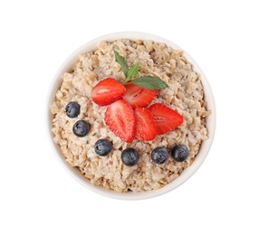 Photo of Tasty boiled oatmeal with berries in bowl isolated on white, top view