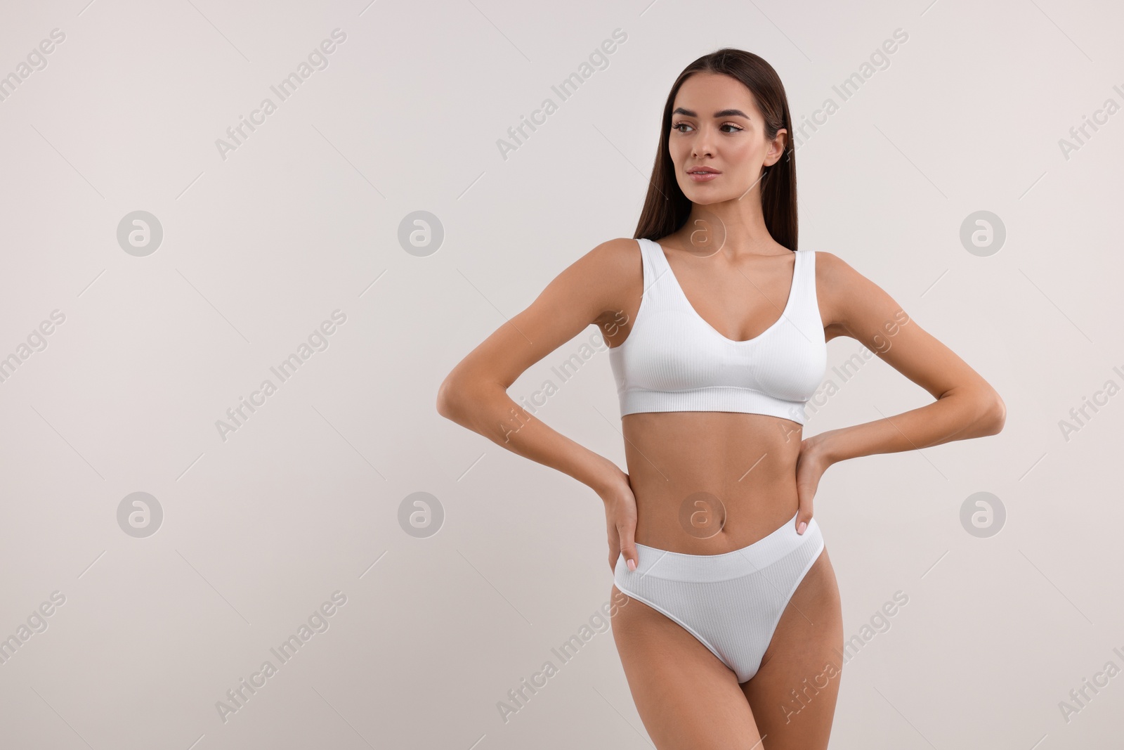 Photo of Young woman in stylish bikini on white background. Space for text