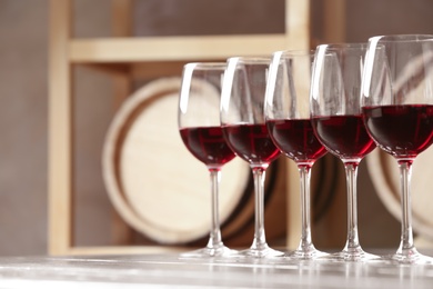 Photo of Glasses with delicious red wine on table