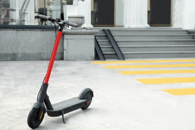 Photo of Modern electric scooter on city street, space for text. Rental service