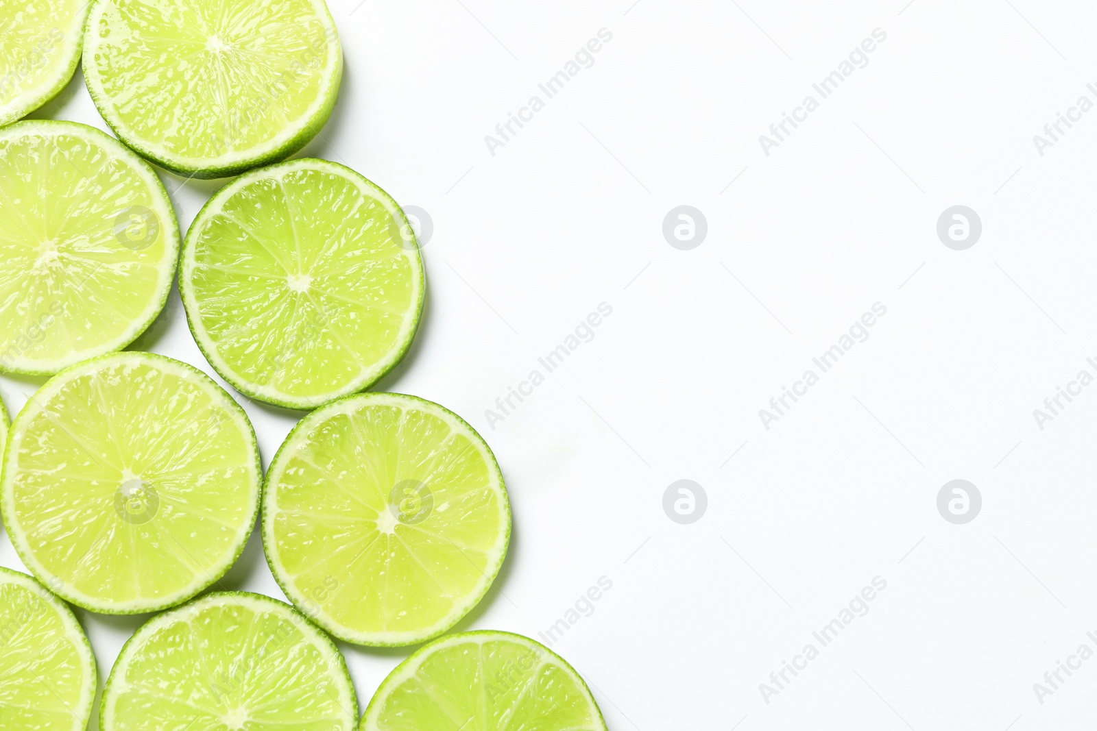 Photo of Fresh juicy lime slices on white background, flat lay. Space for text