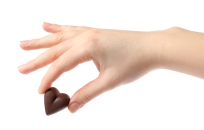 Woman holding heart shaped chocolate candy on white background, closeup