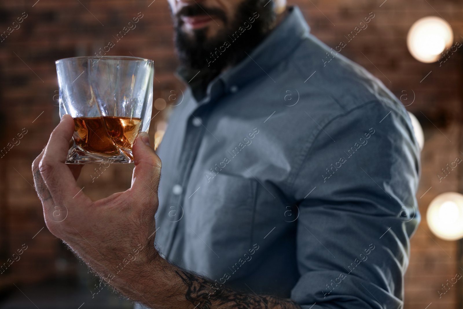 Photo of Man with glass of whiskey indoors, closeup