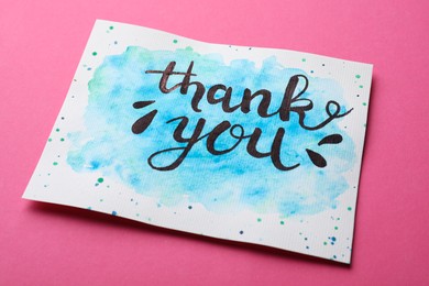 Photo of Card with phrase Thank You on pink background