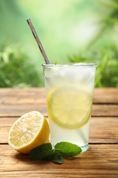 Photo of Natural lemonade with mint and fresh fruit on wooden table. Summer refreshing drink