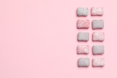 Photo of Tasty colorful bubble gums on pink background, flat lay. Space for text