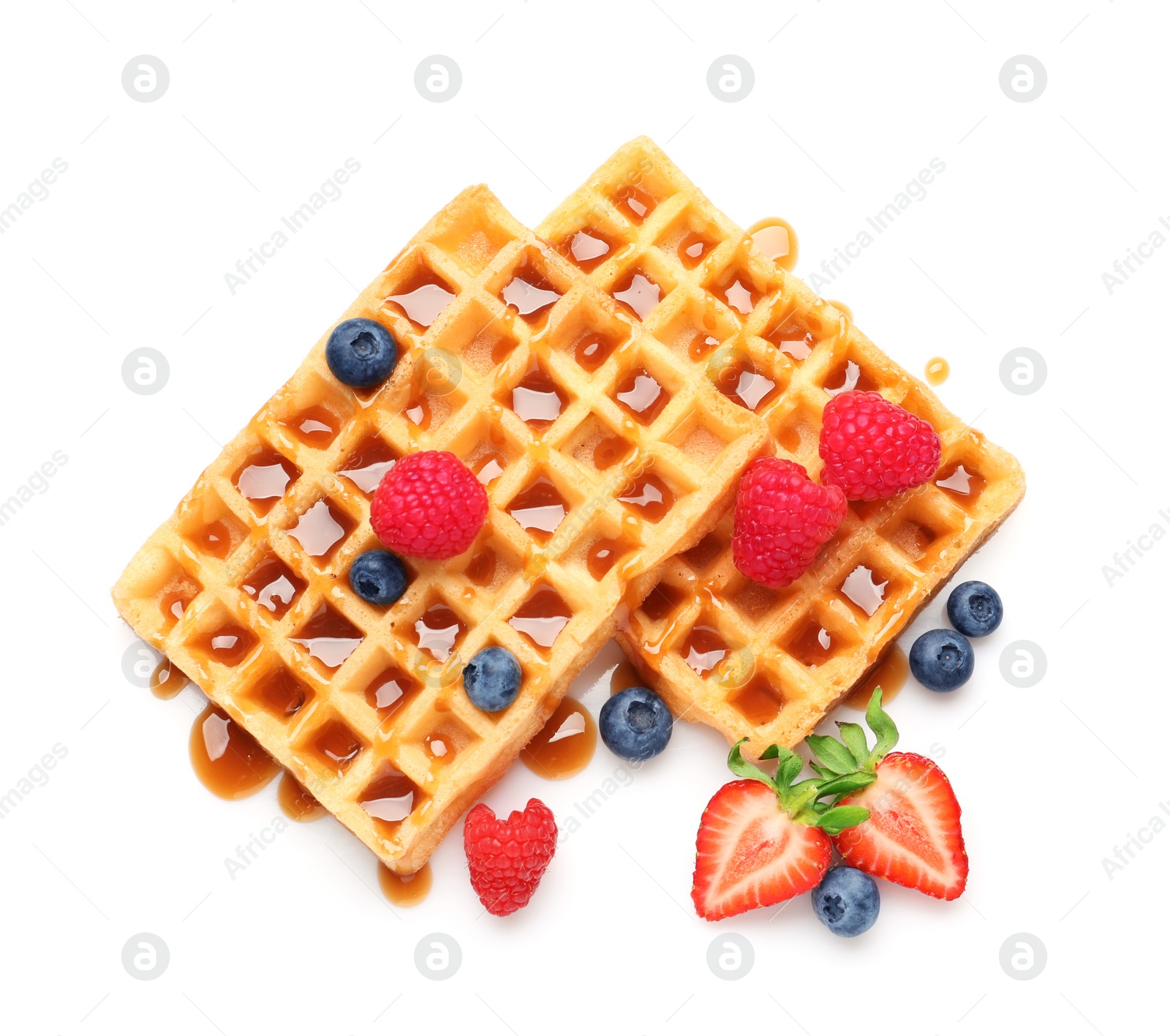 Photo of Yummy waffles with berries and caramel syrup on white background, top view