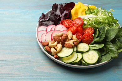 Photo of Balanced diet and vegetarian foods. Plate with different delicious products on light blue wooden table. Space for text