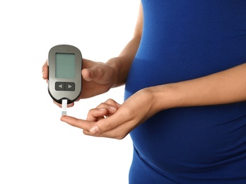 Photo of Pregnant woman checking blood sugar level with glucometer on white background. Diabetes test
