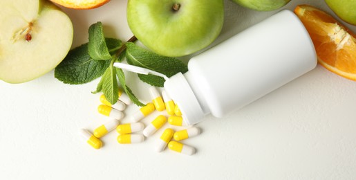 Photo of Bottle with vitamin pills and fruits on white table, flat lay. Space for text