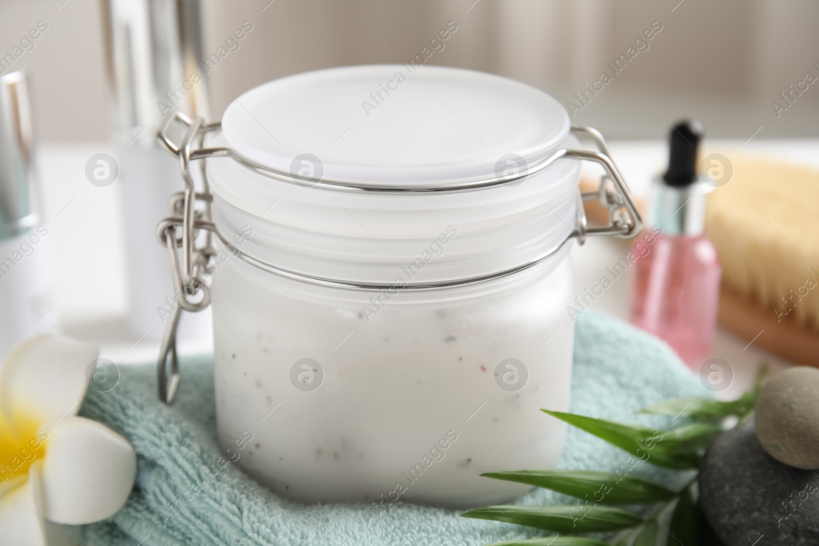 Photo of Jar of salt scrub and towel on table, closeup