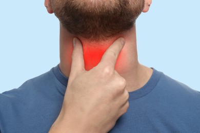 Endocrine system. Man doing thyroid self examination on light blue background, closeup