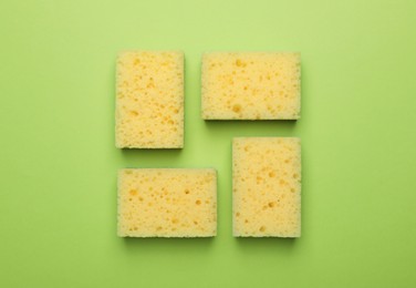 Flat lay composition with sponges on green background