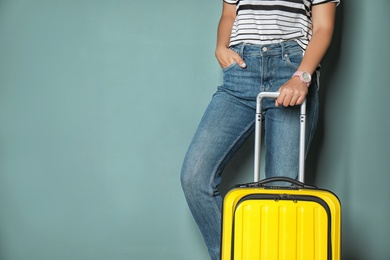 Photo of Woman with bright yellow suitcase on color background