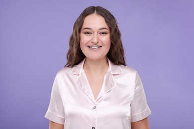 Photo of Smiling woman with dental braces on violet background