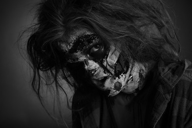 Scary zombie on dark background, black and white effect. Halloween monster