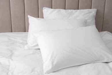 Photo of White soft pillows on comfortable bed indoors