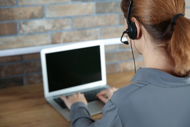 Female technical support operator with headset at workplace