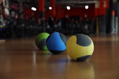 Photo of Medicine balls on floor in gym. Space for text