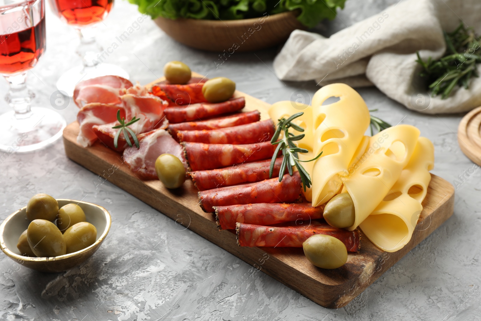 Photo of Delicious charcuterie board served on light grey table