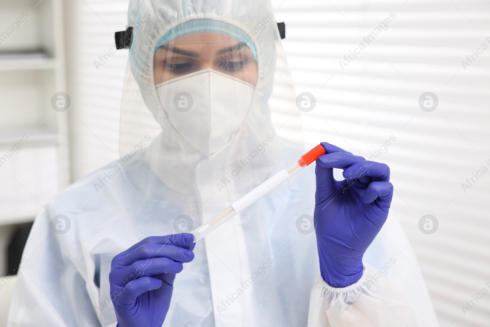 Photo of Laboratory testing. Doctor in uniform with cotton swab and tube at hospital