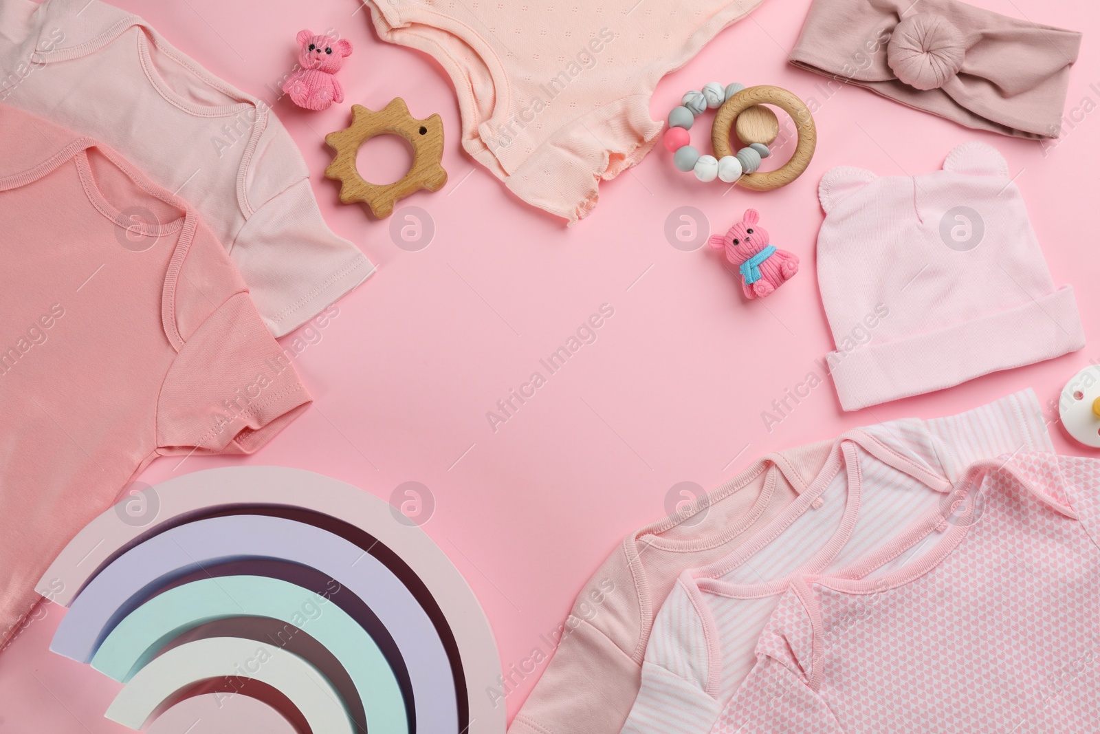 Photo of Frame of baby clothes and accessories on pink background, flat lay. Space for text