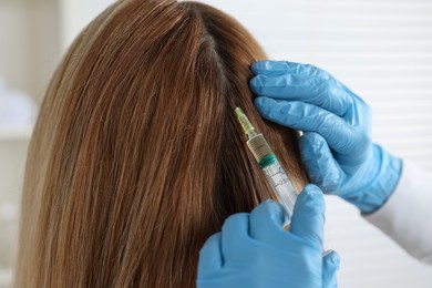 Trichologist giving injection to patient in clinic, closeup