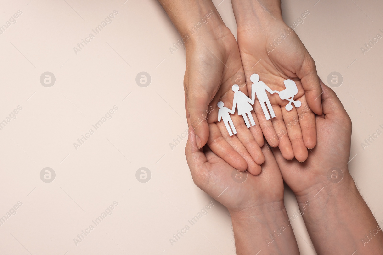 Photo of Couple holding paper family figures on beige background, top view with space for text. Insurance concept