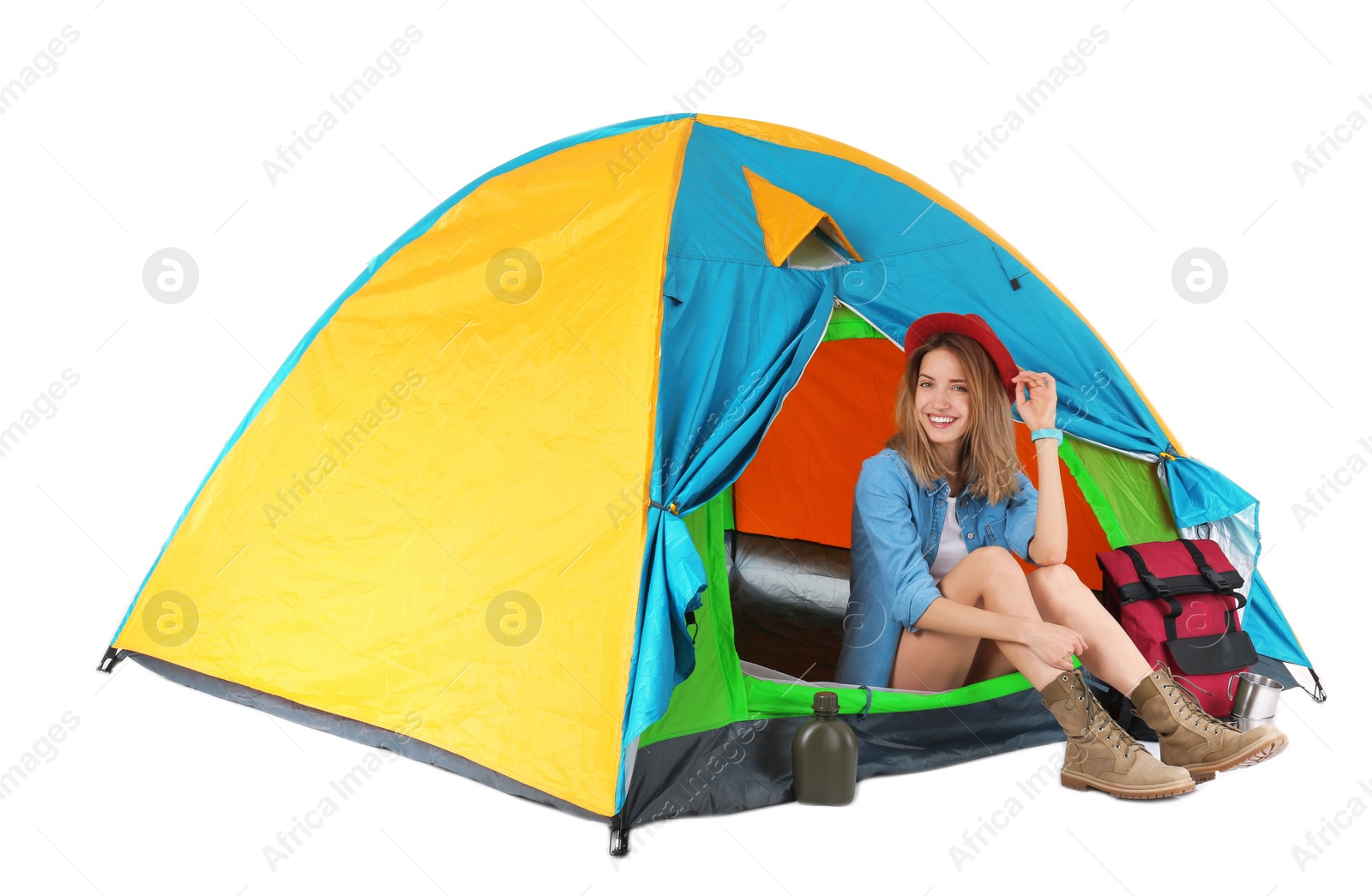 Photo of Young beautiful woman sitting in tourist tent on white background
