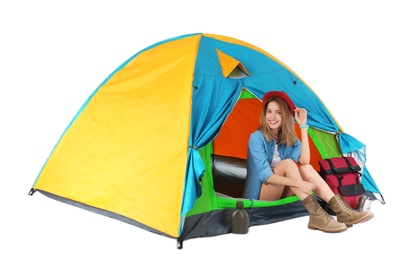 Young beautiful woman sitting in tourist tent on white background