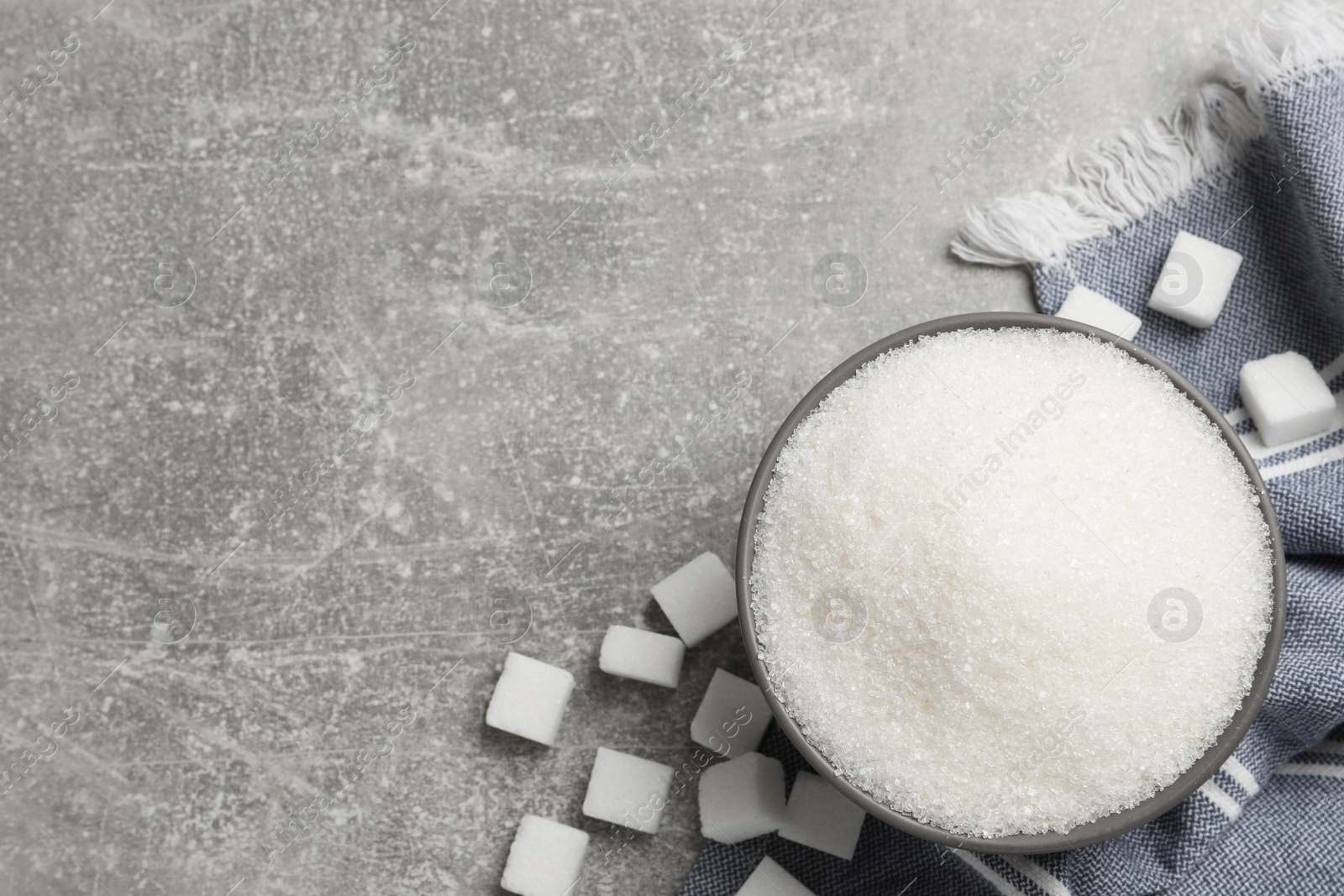 Photo of Bowl of white sugar on light grey table, flat lay, Space for text