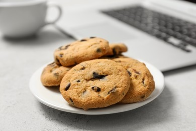 Chocolate chip cookies on light gray table in office, closeup