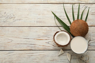 Photo of Delicious vegan milk and coconuts on white wooden table, flat lay. Space for text