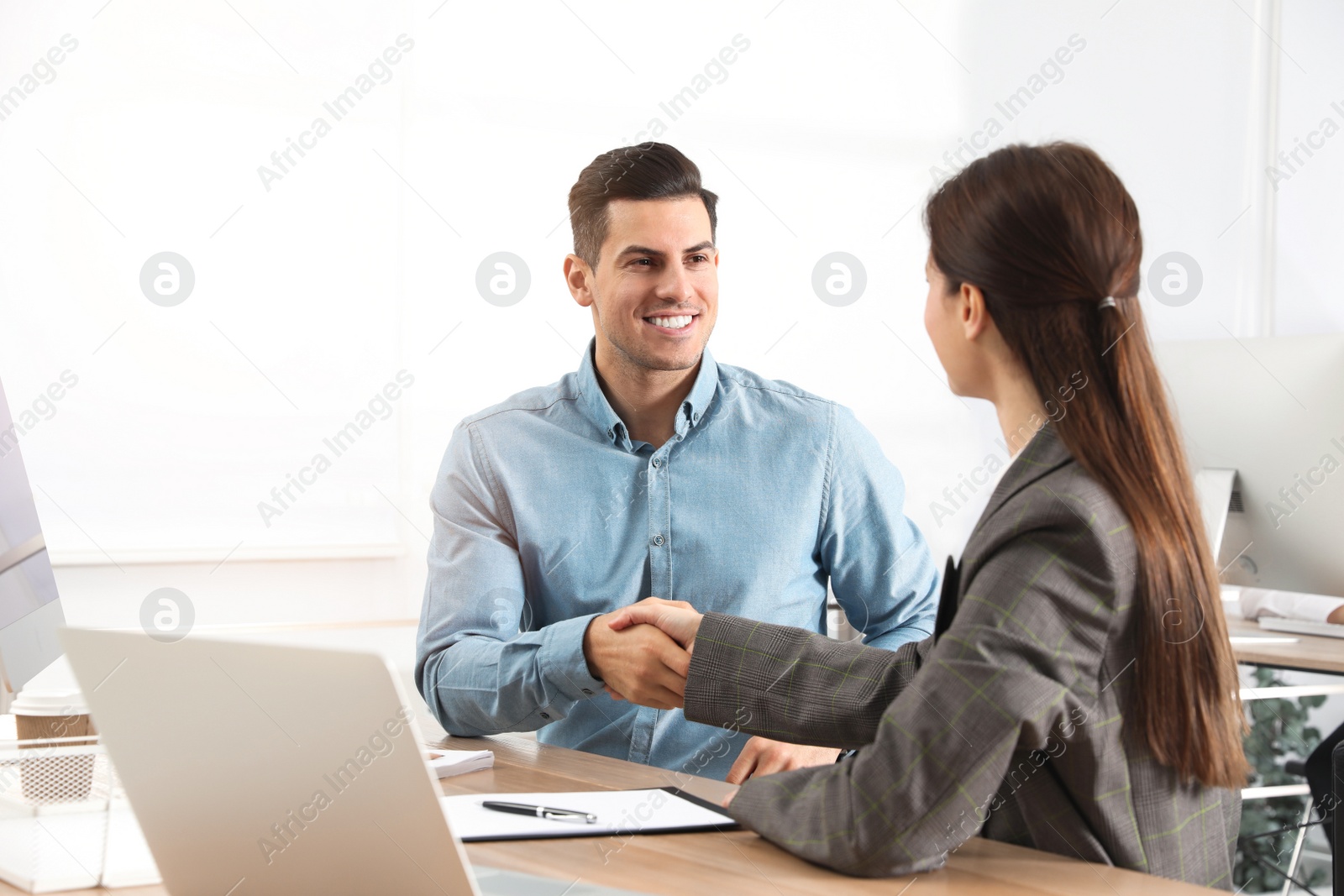 Photo of Employee shaking hands with intern in office