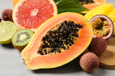 Photo of Fresh ripe papaya and other fruits on white wooden table, closeup