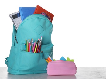 Modern backpack with stationery on white background