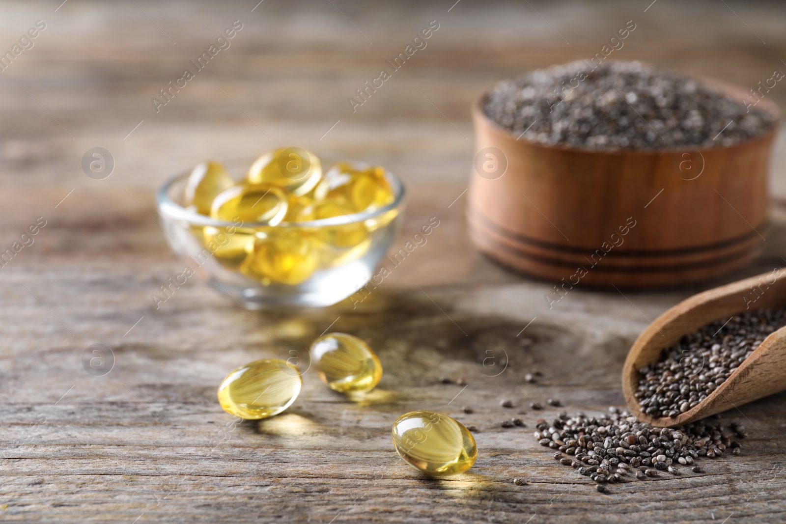 Photo of Chia oil capsules and scoop with seeds on table. Space for text