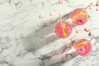 Photo of Refreshing drink with lemon and rose on white marble table, flat lay. Space for text