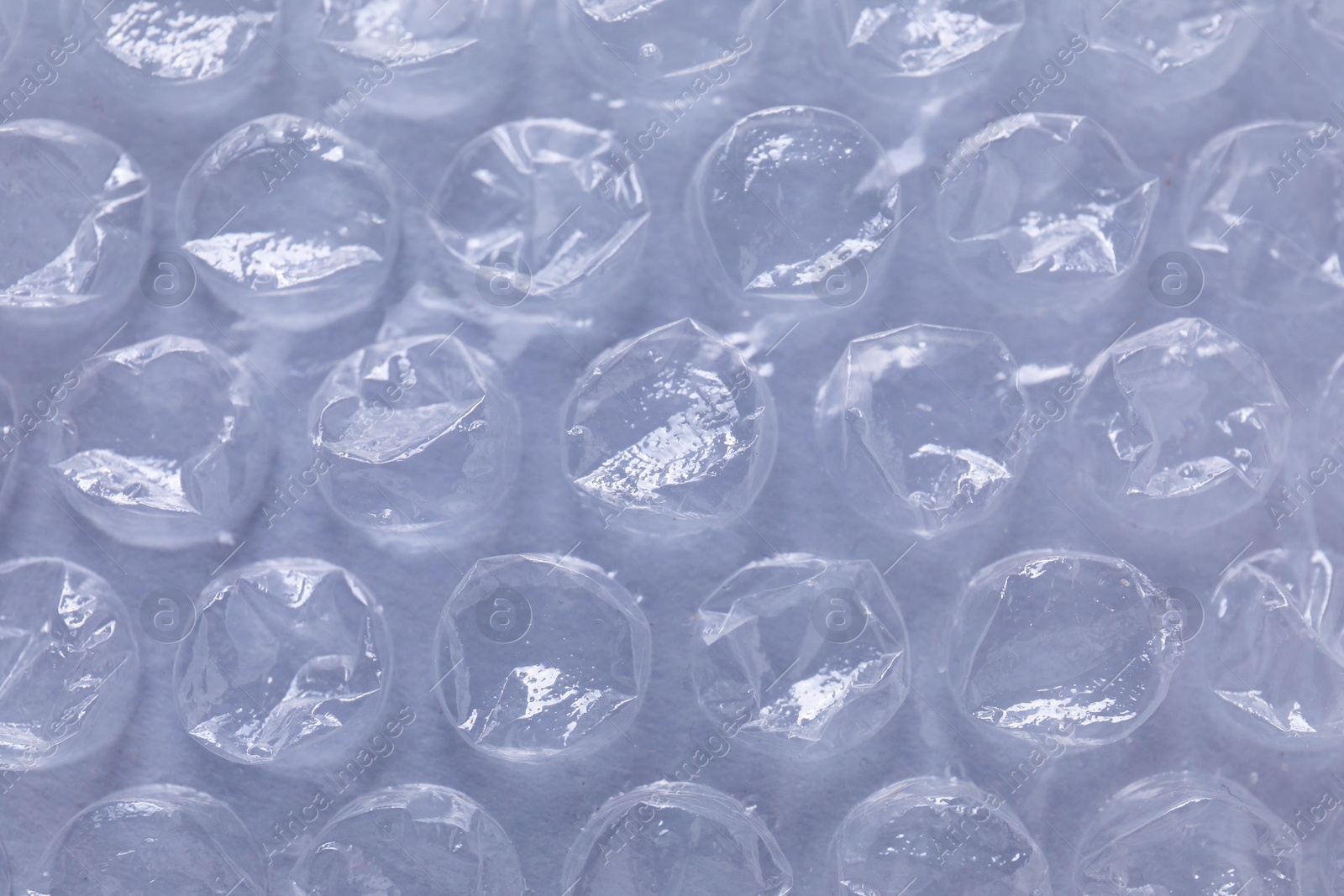 Photo of Transparent bubble wrap on gray background, closeup