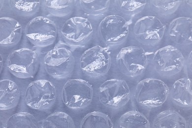 Photo of Transparent bubble wrap on gray background, closeup