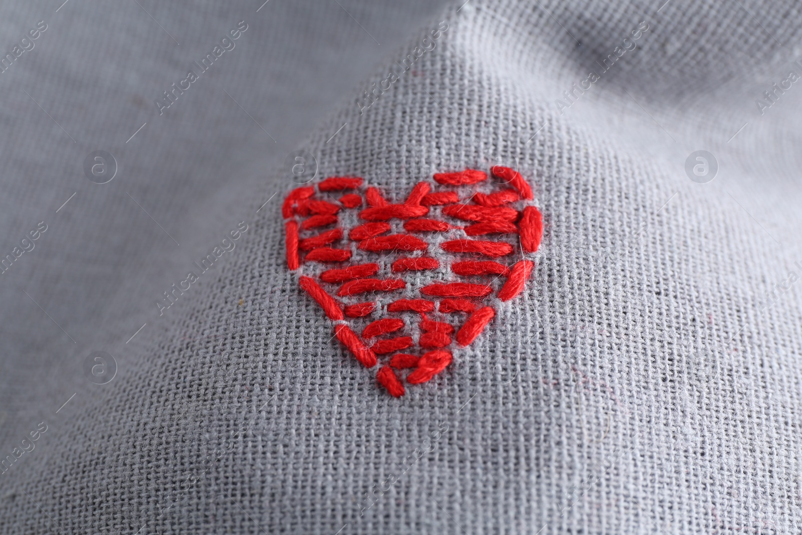 Photo of Embroidered red heart on gray cloth, above view