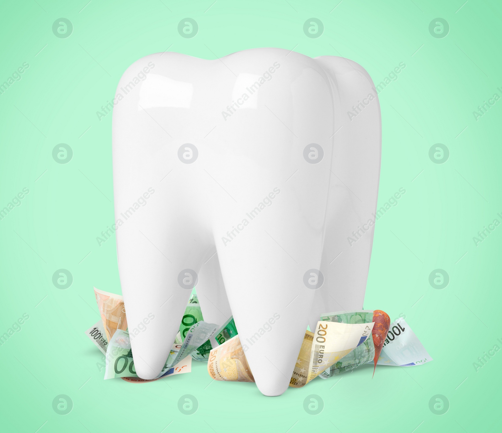 Image of Model of tooth and euro banknotes on turquoise background. Concept of expensive dental procedures