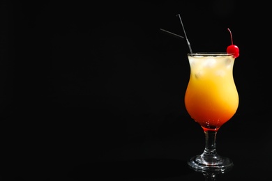 Photo of Glass of cocktail Sex on the Beach, black background. Space for text