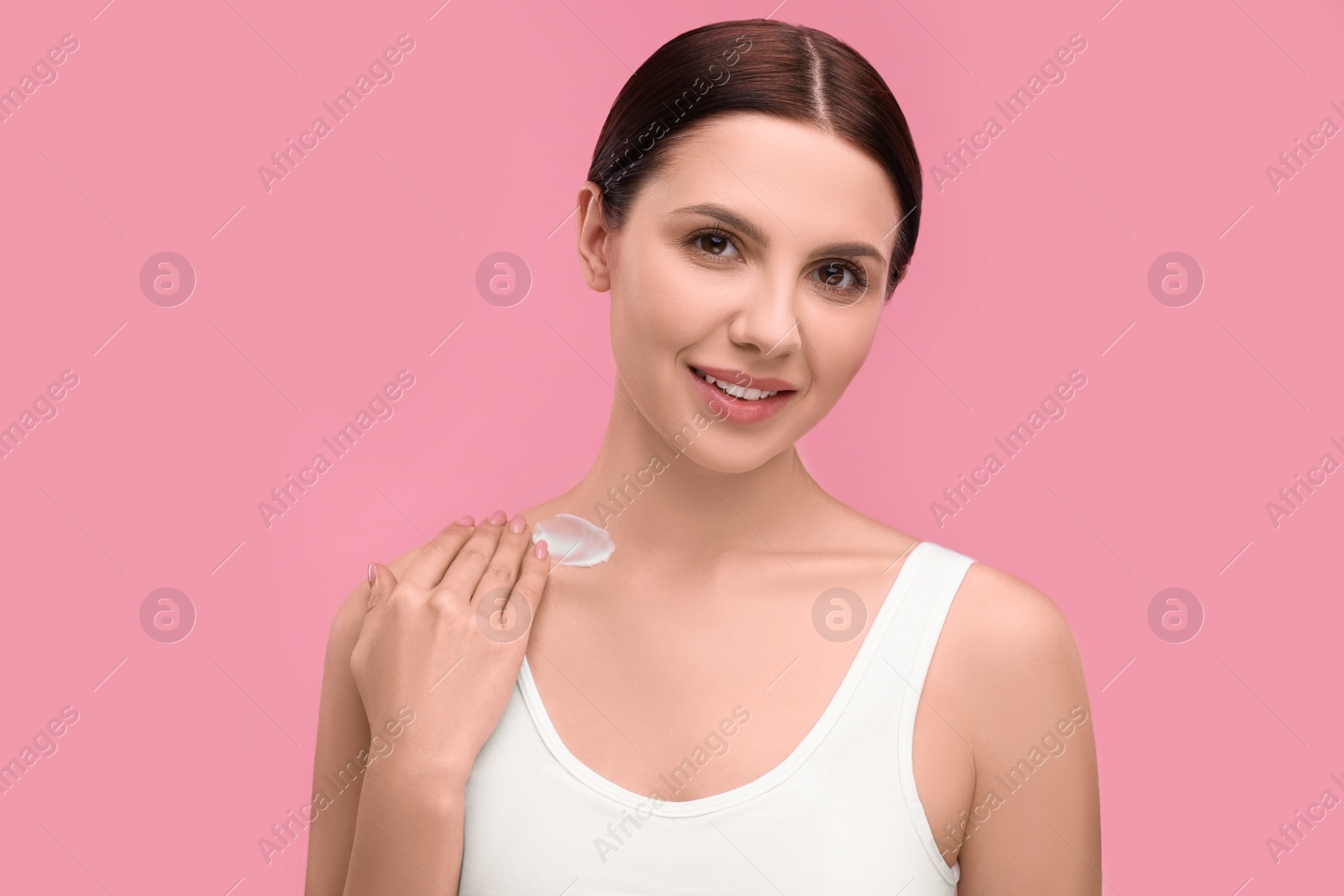 Photo of Beautiful woman with smear of body cream on pink background