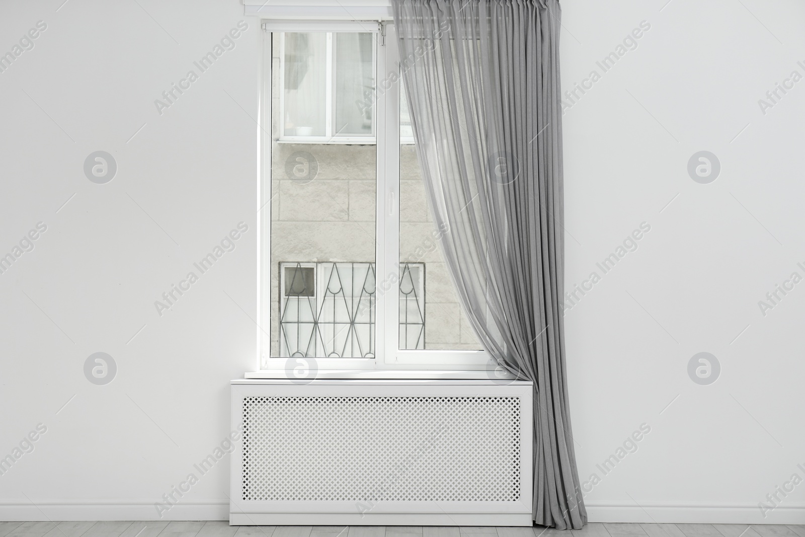 Photo of Light room with window and open curtains. Home interior