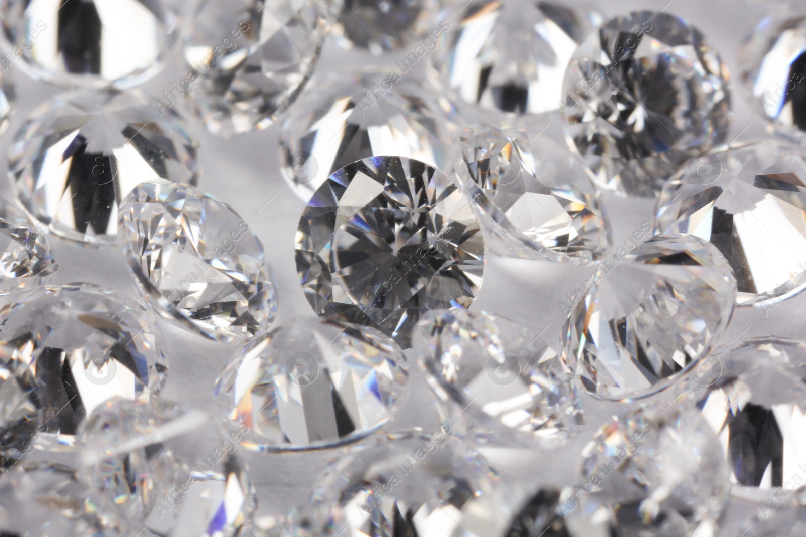 Photo of Many beautiful shiny diamonds on light background, closeup