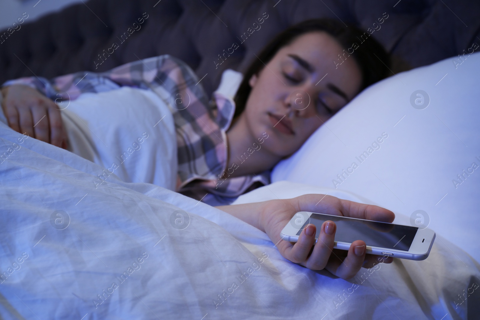 Photo of Lonely woman sleeping with smart phone in bed, closeup