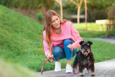 Young woman with Miniature Schnauzer dog in park